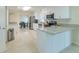 Bright, modern kitchen with white cabinets, stainless steel appliances, and marble countertops and tile flooring at 4725 Soapstone Dr, Tampa, FL 33615