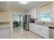 Bright kitchen features white cabinets, tile backsplash and stainless steel appliances overlooking the dining area at 4725 Soapstone Dr, Tampa, FL 33615