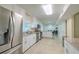 Open kitchen featuring stainless steel appliances, white cabinets, and a view into the dining room and hallway at 4725 Soapstone Dr, Tampa, FL 33615