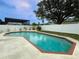 Backyard boasts a private pool surrounded by a concrete deck and white fencing for relaxation and enjoyment at 4725 Soapstone Dr, Tampa, FL 33615