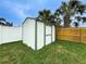 Outdoor shed in the backyard offers extra storage, surrounded by green grass and palm trees at 4725 Soapstone Dr, Tampa, FL 33615