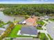 An aerial view showcases a property with a pool, backing onto a serene lake and lush green trees at 630 Lake Cypress Cir, Oldsmar, FL 34677