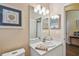 Cozy bathroom with neutral walls, white vanity with small sink, and decorative seashell art at 630 Lake Cypress Cir, Oldsmar, FL 34677