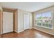 Bedroom with hardwood floors, a double closet, and a window overlooking the backyard at 630 Lake Cypress Cir, Oldsmar, FL 34677
