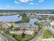 An aerial view of the condo community, featuring views of a lake, lush greenery, and residential buildings at 6330 99Th N Way # 14B, Seminole, FL 33708
