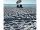 Beach scene with two people enjoying the view under an umbrella at 6330 99Th N Way # 14B, Seminole, FL 33708