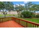 Orange wood deck overlooks lush landscaping with manicured lawn and trees in front of a condo building at 6330 99Th N Way # 14B, Seminole, FL 33708