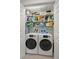 Organized laundry room featuring modern washer and dryer units with storage shelving and blue paint at 6330 99Th N Way # 14B, Seminole, FL 33708