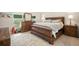 Cozy main bedroom with warm wood furniture, a large mirror, and natural light from the windows at 6330 99Th N Way # 14B, Seminole, FL 33708