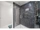 Close-up of a modern shower showcasing sleek, dark tiling and a frameless glass door at 6330 99Th N Way # 14B, Seminole, FL 33708