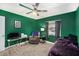 The bedroom features green walls and a gray carpet with an accent recliner and desk at 6346 Bonnie Bay N Cir, Pinellas Park, FL 33781