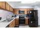 Efficient kitchen featuring wood cabinets and modern black appliances at 6346 Bonnie Bay N Cir, Pinellas Park, FL 33781