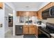 Cozy kitchen with wood cabinetry, stainless steel sink, and view into the living area at 6346 Bonnie Bay N Cir, Pinellas Park, FL 33781