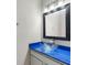 Bathroom featuring a glass bowl sink atop a blue counter, complemented by a black framed mirror at 6706 47Th N St, Pinellas Park, FL 33781