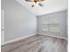 Bedroom with hardwood floors, ceiling fan, window, and light grey walls at 6706 47Th N St, Pinellas Park, FL 33781