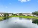 Scenic view of the back of townhomes overlooking a serene lake with lush green surroundings at 6706 47Th N St, Pinellas Park, FL 33781