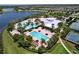 Resort-style pool area with multiple pools, water slide, and lounge chairs surrounded by lush landscaping and mature palm trees at 6932 Old Benton Dr, Apollo Beach, FL 33572