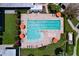 Aerial view of the rectangular swimming pool with umbrellas, lounge chairs, and meticulous landscaping, perfect for community fun at 6932 Old Benton Dr, Apollo Beach, FL 33572