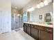 Well-lit bathroom features a double vanity and a glass-enclosed shower creating a clean aesthetic at 6932 Old Benton Dr, Apollo Beach, FL 33572