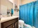 Cozy bathroom featuring a toilet, sink, and a blue shower curtain creating a functional space at 6932 Old Benton Dr, Apollo Beach, FL 33572