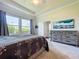 Bright bedroom featuring a comfortable bed, neutral decor, and a view of the landscaped exterior at 6932 Old Benton Dr, Apollo Beach, FL 33572