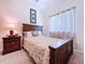 Cozy bedroom featuring wood furniture, a comfortable bed, and soft natural lighting from the window at 6932 Old Benton Dr, Apollo Beach, FL 33572