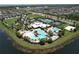 Beautiful aerial view of the community pool with tropical landscaping and white clubhouse at 6932 Old Benton Dr, Apollo Beach, FL 33572