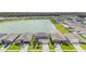 Aerial view of a neighborhood with a large pond and many two-story homes with light-blue facades at 8576 Broadstone Dr, Wesley Chapel, FL 33544