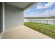 Covered back porch overlooking fenced backyard and scenic lake view at 8576 Broadstone Dr, Wesley Chapel, FL 33544