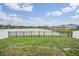 Spacious backyard with an iron fence and a picturesque lake view at 8576 Broadstone Dr, Wesley Chapel, FL 33544