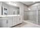 Bright bathroom featuring a double sink vanity with white cabinets and a spacious walk-in shower with glass doors at 8576 Broadstone Dr, Wesley Chapel, FL 33544