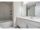 Modern bathroom featuring a tiled bathtub/shower combo and a vanity with white cabinets and a quartz countertop at 8576 Broadstone Dr, Wesley Chapel, FL 33544