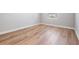 Unfurnished bedroom featuring wood-style floors, base trim, and natural light at 8576 Broadstone Dr, Wesley Chapel, FL 33544