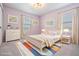 Cozy staged bedroom with a comfortable bed, colorful rug, and dresser at 8576 Broadstone Dr, Wesley Chapel, FL 33544