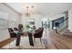 Dining room features wood floors, a modern chandelier, and a glass top dining table at 8576 Broadstone Dr, Wesley Chapel, FL 33544