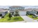 Two-story home features a light-blue facade, a two-car garage, and a well-manicured lawn at 8576 Broadstone Dr, Wesley Chapel, FL 33544