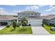 Two-story home features a light-blue facade, a two-car garage, and a well-manicured lawn at 8576 Broadstone Dr, Wesley Chapel, FL 33544