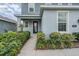 Inviting front entrance with well-maintained landscaping, a covered porch, and a dark blue front door at 8576 Broadstone Dr, Wesley Chapel, FL 33544