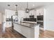 Modern kitchen with white cabinets, stainless steel appliances, and large island with granite countertop at 8576 Broadstone Dr, Wesley Chapel, FL 33544