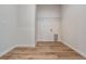 Simple laundry room with wood floors, white walls, wire shelf, and appliance hookups at 8576 Broadstone Dr, Wesley Chapel, FL 33544
