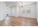 Bright living room features wood floors, a modern chandelier, and a glass front door at 8576 Broadstone Dr, Wesley Chapel, FL 33544