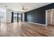 Bright, open floor plan featuring wood floors, dark accent wall, and sliding glass doors to lake view at 8576 Broadstone Dr, Wesley Chapel, FL 33544