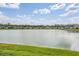 Picturesque pond view surrounded by lush green grass and neighboring homes at 8576 Broadstone Dr, Wesley Chapel, FL 33544