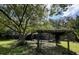 The backyard boasts mature trees, lush greenery, and a charming arbor, perfect for outdoor relaxation at 939 Woodland Dr, Palm Harbor, FL 34683