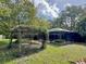 A lush backyard featuring pergola and screened-in enclosure at 939 Woodland Dr, Palm Harbor, FL 34683