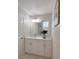 This bathroom features modern white cabinets, quartz counters, and updated lighting at 939 Woodland Dr, Palm Harbor, FL 34683