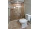 A tiled shower features a glass enclosure and built-in bench adjacent to the toilet at 939 Woodland Dr, Palm Harbor, FL 34683