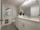 A full bathroom with modern white cabinets, quartz counters, and updated lighting at 939 Woodland Dr, Palm Harbor, FL 34683