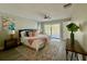 This spacious bedroom features a ceiling fan, sliding glass door, and a large rug at 939 Woodland Dr, Palm Harbor, FL 34683
