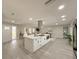 Open concept kitchen with a center island, stainless steel hood, and sleek gray flooring at 939 Woodland Dr, Palm Harbor, FL 34683